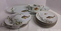 Wide shot of entire set including platter, covered dish, gravy boat, and plates