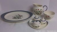 Full view of the Wedgwood Mayfield serving set, showing platter, jug, bowl, and cruet set on tray with floral decorations and blue rims