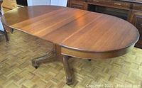 Full view of antique oak dining table with 3 sections closed.