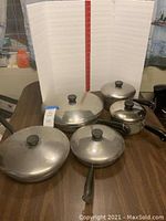 Full set view on table with lids attached, showing size variety and handle style