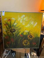Full view of large framed acrylic sunflower painting 41 x 41 inches on easel with yellow background and red, white flowers