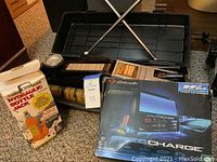 Photo of the lot showing the hydraulic bottle jack, carrying case, and Schumacher electric charger boxed packaging.