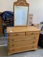Wooden chest of drawers with 4 drawers and wooden knob handles, natural wood finish, showing minor wear.