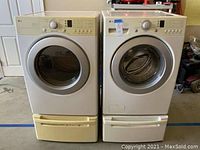 Front view of washer and dryer units side by side on pedestal drawers