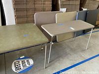 Six folding card tables seen in a row, showing tops and legs with wear and tape labels.