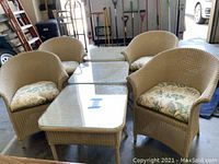 Group view of four wicker chairs and three glass-top tables in garage