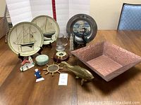 Overview of all nautical decor items including plates, metal art pieces, figurines, and bowl