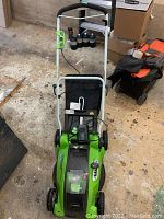 Front view of mower showing deck, wheels and grass bag