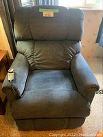 Front view of blue La-Z-Boy lift recliner chair with remote on armrest.