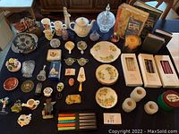 Overview of all lot contents showing various china, decor, kitchenware, candles, and photo albums