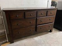 Front view of dark brown wooden 8-drawer dresser