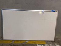 Full view of the dry erase board showing the entire surface with some visible scratches and markings.