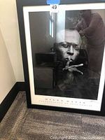 Full view of framed Miles Davis photograph showing frame, mat, image and printed text at bottom.