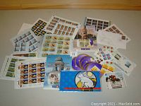 Wide view of all stamps and envelopes in the lot spread on a surface