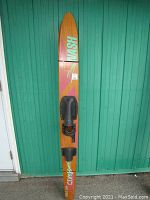 Full view of one vintage Nash water ski showing wood grain, foot bindings, and branding.