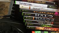 Close-up of Xbox game cases stacked to show titles: Buffy the Vampire Slayer, Spider-Man, Rainbow Six 3, Halo, Halo 2, House of the Dead III, Hulk, Fable.