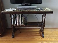Photo of vintage wooden magazine side-table with VCR, television, and books