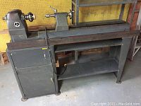 Full view of lathe on stand showing headstock, tailstock, tool rest and lower shelf.