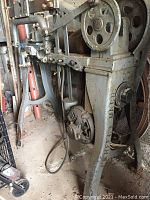 Photo of side view showing the machine's frame, pulleys, and linkages.