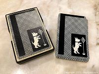 Photo showing front and back of matching card case and card deck backs with black and white Scottie dog design.