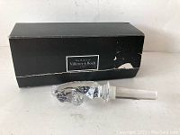 Photo showing the glass horse head decanter stopper lying next to its original black box with Villeroy & Boch label.