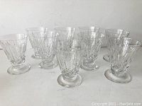 Nine crystal glasses arranged together showing the cross and olive pattern and their size.
