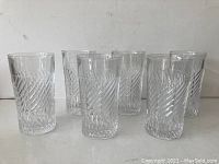 Six heavy vintage glass drinking glasses arranged in a group showing the diagonal ribbed texture.