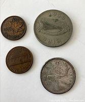 Four coins laid on a flat surface showing different sides with dates 1968, 1959, 1947, and 1963 visible.