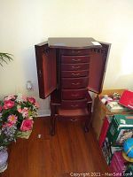 Full view of wooden jewelry chest with both side doors open showing six drawers and interior hooks for jewelry hanging.
