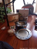 Full lot arranged on wooden floor showing Mikasa salad bowl, metal pedestal plate, lamp, boxes, frame, and additional decor items.