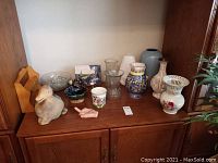 Overall view of various vases, bowls, figurines, and decorative items on wooden furniture