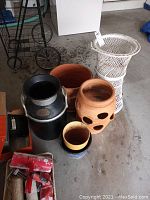 Photo showing all items including the Standard Oil Co jug, various planters, and the wicker plant stand.