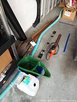 Overview of yard tools including shovels, rake, Craftsman hedge trimmer, garden cart, watering can and blue hose