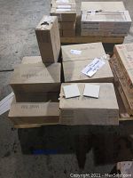 Stack of 11 cartons of American Olean ceramic wall tiles in almond color, some boxes sealed, one box open