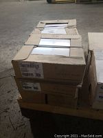 Six cartons of tiles stacked, with one carton opened on top showing tiles inside.