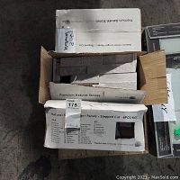Three boxes of stepped cut natural stone ledger panels, open top view showing stacked tiles inside.