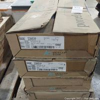 Four stacked cardboard boxes labeled American Olean with model 0A06 22MS1P visible, slightly worn edges.