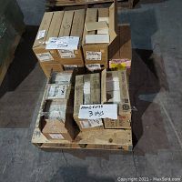 Palet with multiple cartons of boxed ceramic wall tiles, some open showing white/almost almond color tiles.