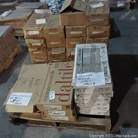 Pallet of multiple cartons of ceramic mosaic and wall tiles from Daltile and Florim in warehouse showing labeling and pallet stacking.