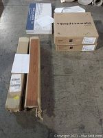 Overview photo showing boxes of wall tiles, hardwood planks, and carpet tiles.