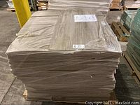 Pallet of wrapped carpet tile planks stacked in warehouse