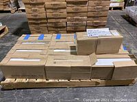 Wooden pallet loaded with multiple cardboard cases of glazed ceramic wall tile.
