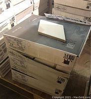 Three stacked boxes of Ceramiche Mutina white diamond-shaped tiles with one tile on top showing subtle herringbone pattern