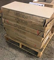 Stacked six boxes of porcelain tiles labeled 'PORCELAIN' on a wooden pallet showing heavy packaging and intact boxes