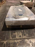 Five shrink-wrapped boxes of COREtec Easy Install flooring on a pallet in warehouse setting.