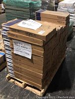 Front view of pallet with stacked Armstrong tile boxes and hand-written note indicating quantities