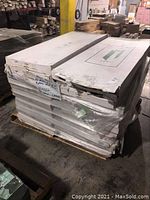 Pallet of boxed white packages wrapped with plastic containing the stair treads, stacked in warehouse.
