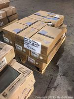 Boxes of American Olean wall tiles stacked on a wooden pallet in warehouse setting. Labels visible with product and dimension information.