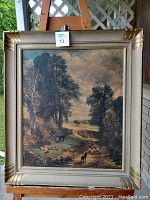 Framed vintage lithograph artwork depicting a rural landscape with trees and animals, showing full view of the item and frame.