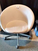Front view of white swivel chair showing the curved bucket seat and cushion
